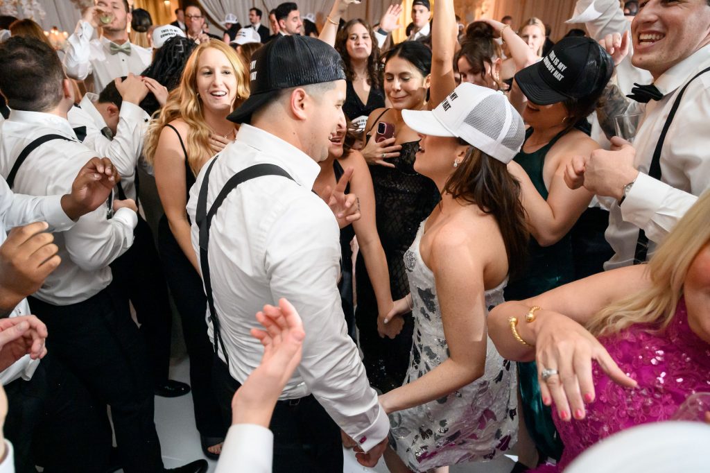 A high-energy dance floor moment, capturing the vibrant Jewish wedding traditions in Austin and Chicago.