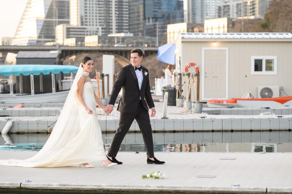 Bride and groom walking together near the yacht club dock at Four Seasons Austin