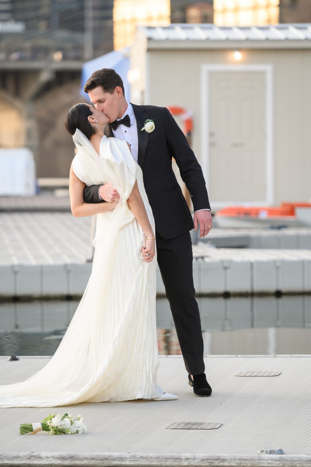 Bride and groom embracing on the dock during sunset portraits at Four Seasons Austin