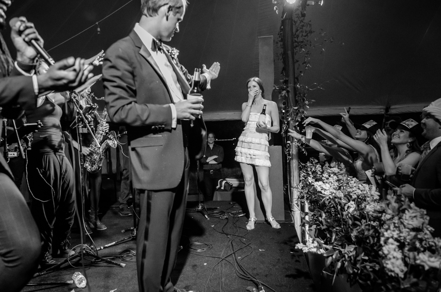 Black and white candid photo of a wedding guest speaking during a reception toast