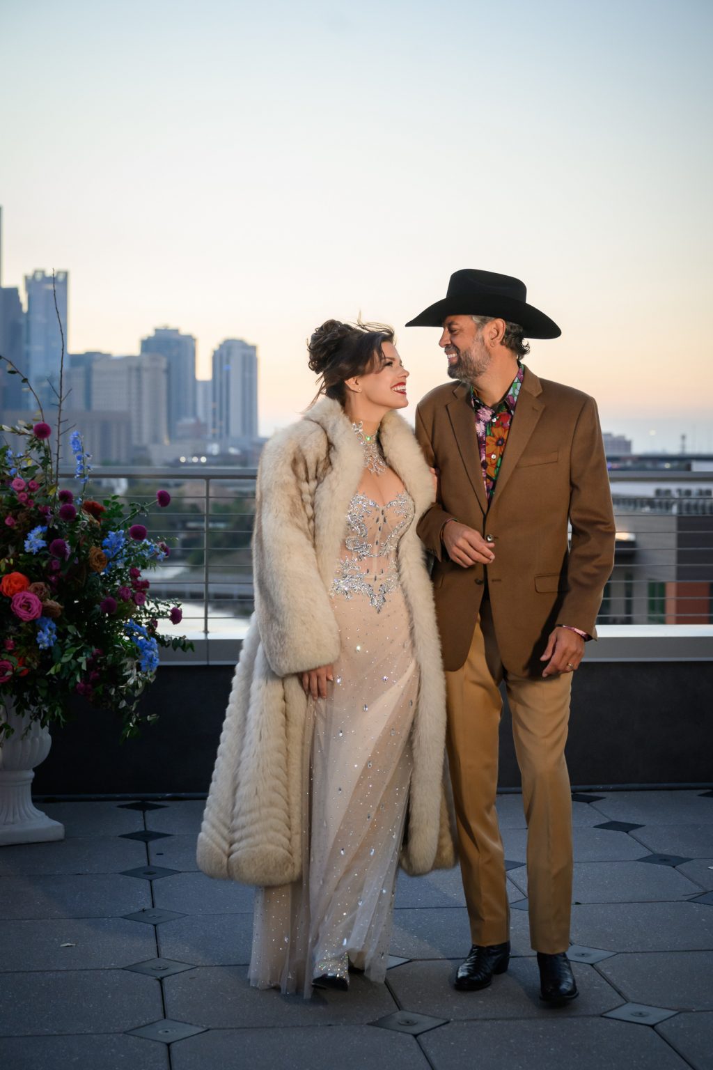 Couple standing together on the terrace with downtown Houston in the background.