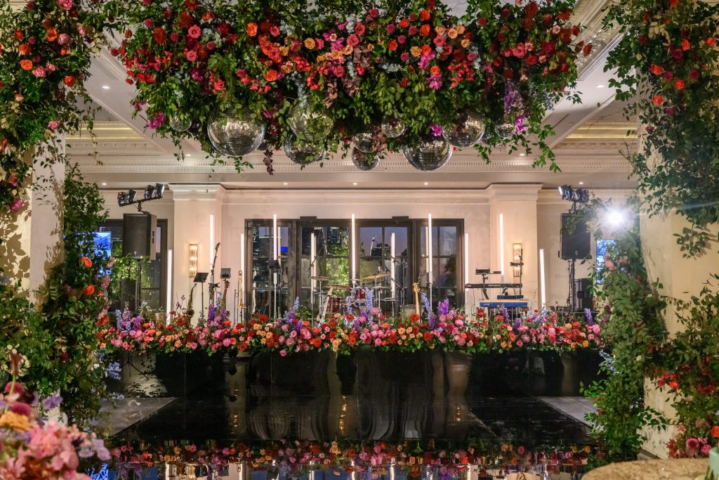 Floral installations framing the reception space at Le Tesserae in Houston featuring the dancefloor and stage facade