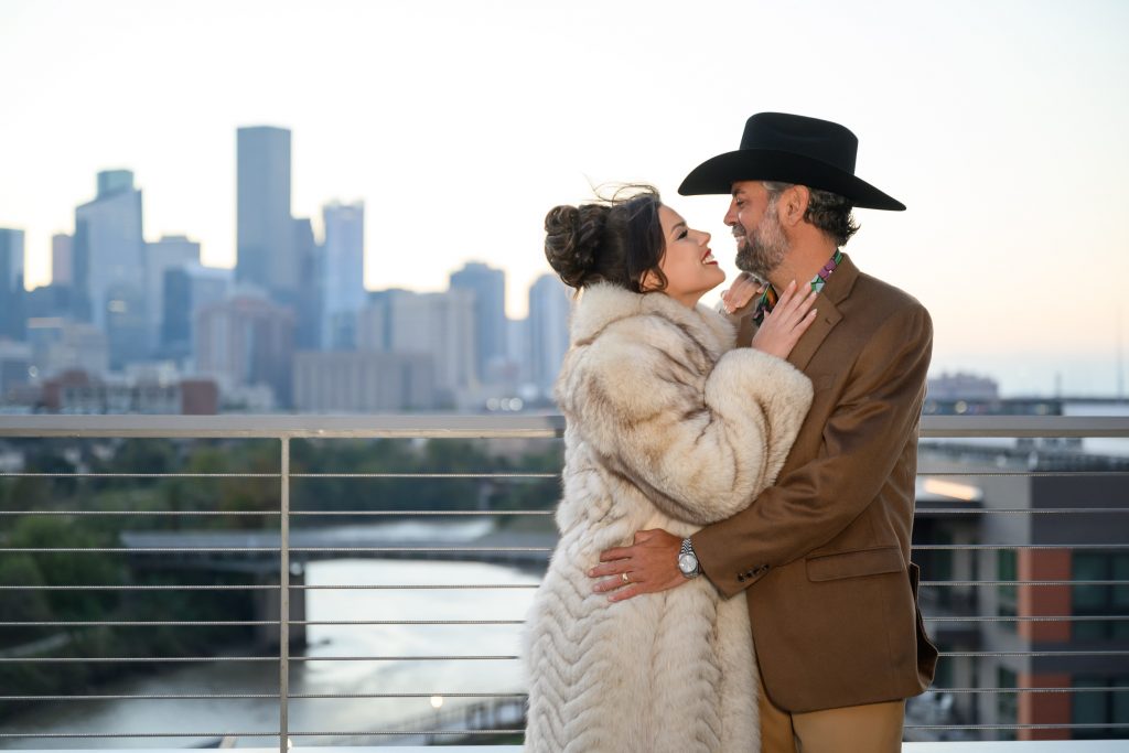 embracing on the terrace at Le Tesserae during their Houston reception.