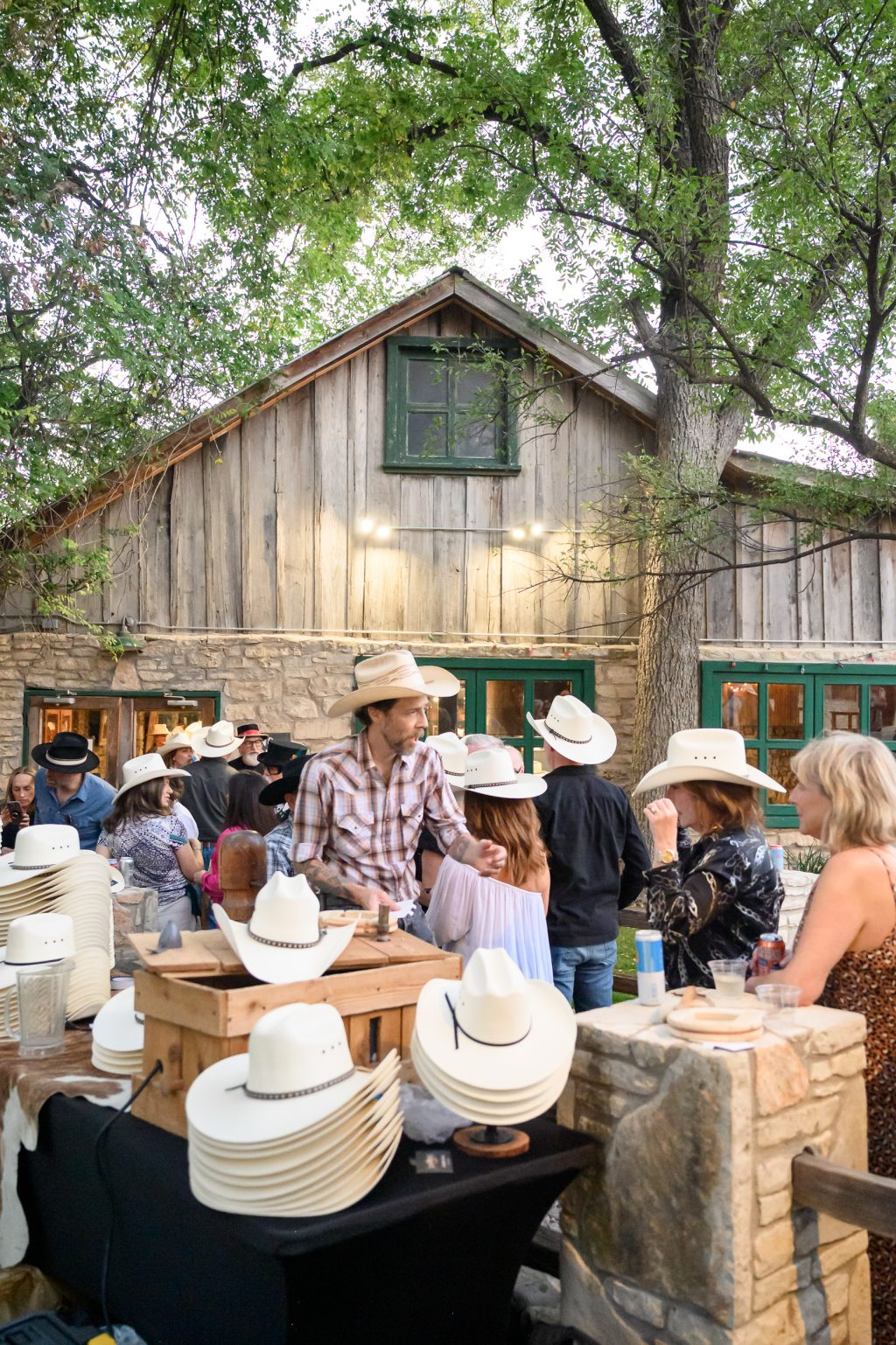 Custom cowboy hats arranged for guests at an Austin wedding rehearsal dinner