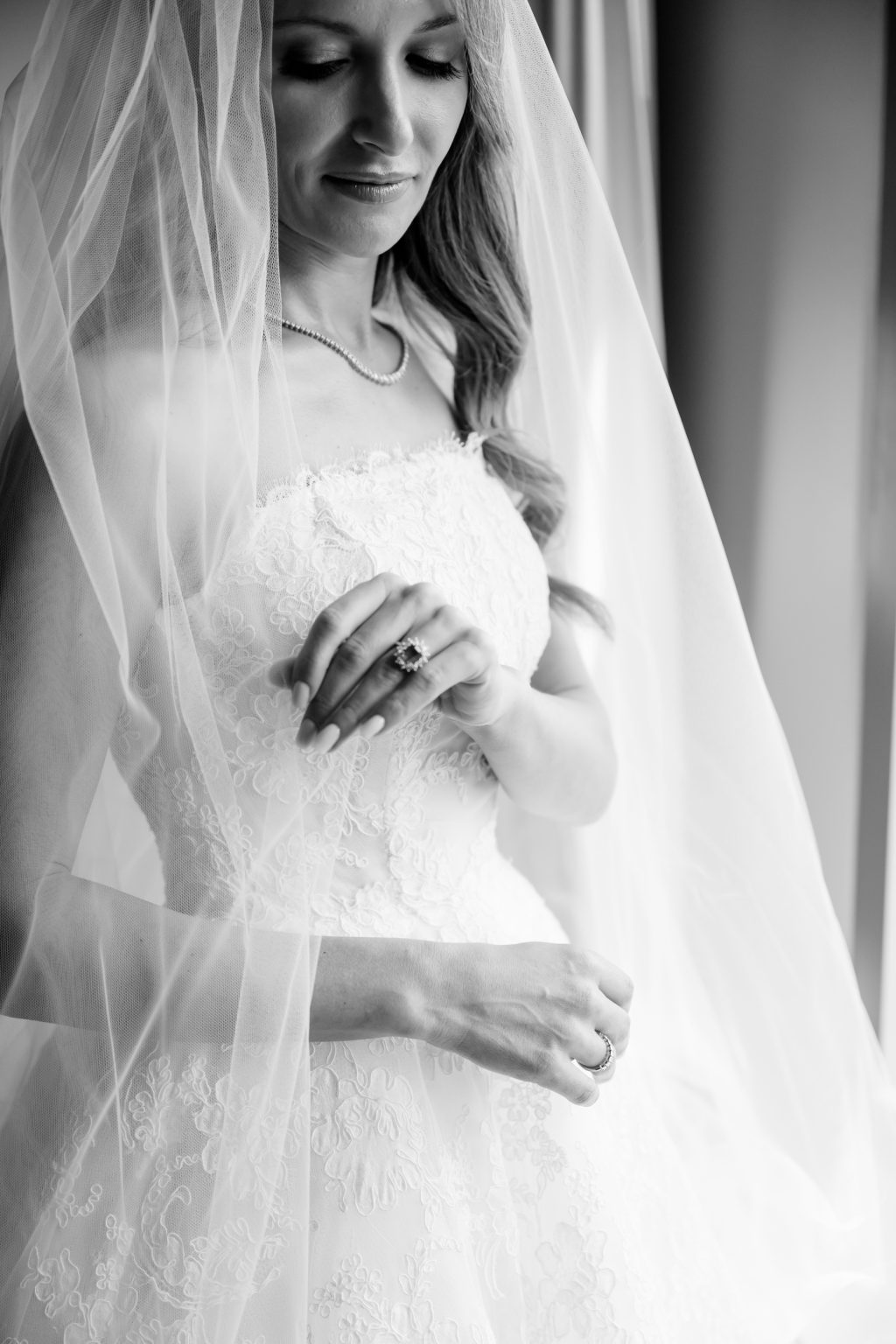 Black and white bridal detail showing lace wedding dress and engagement ring