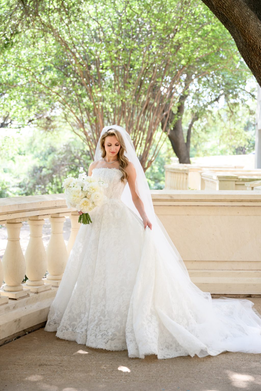Bride in Monique Lhuillier wedding dress on a Four Seasons Austin balcony