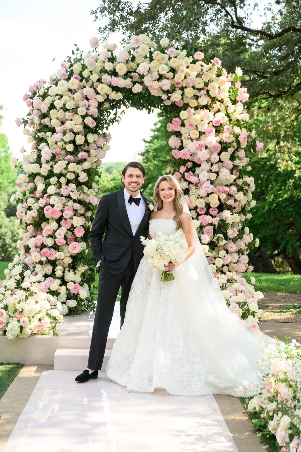 Bride and groom portrait framed by pink and white wedding florals