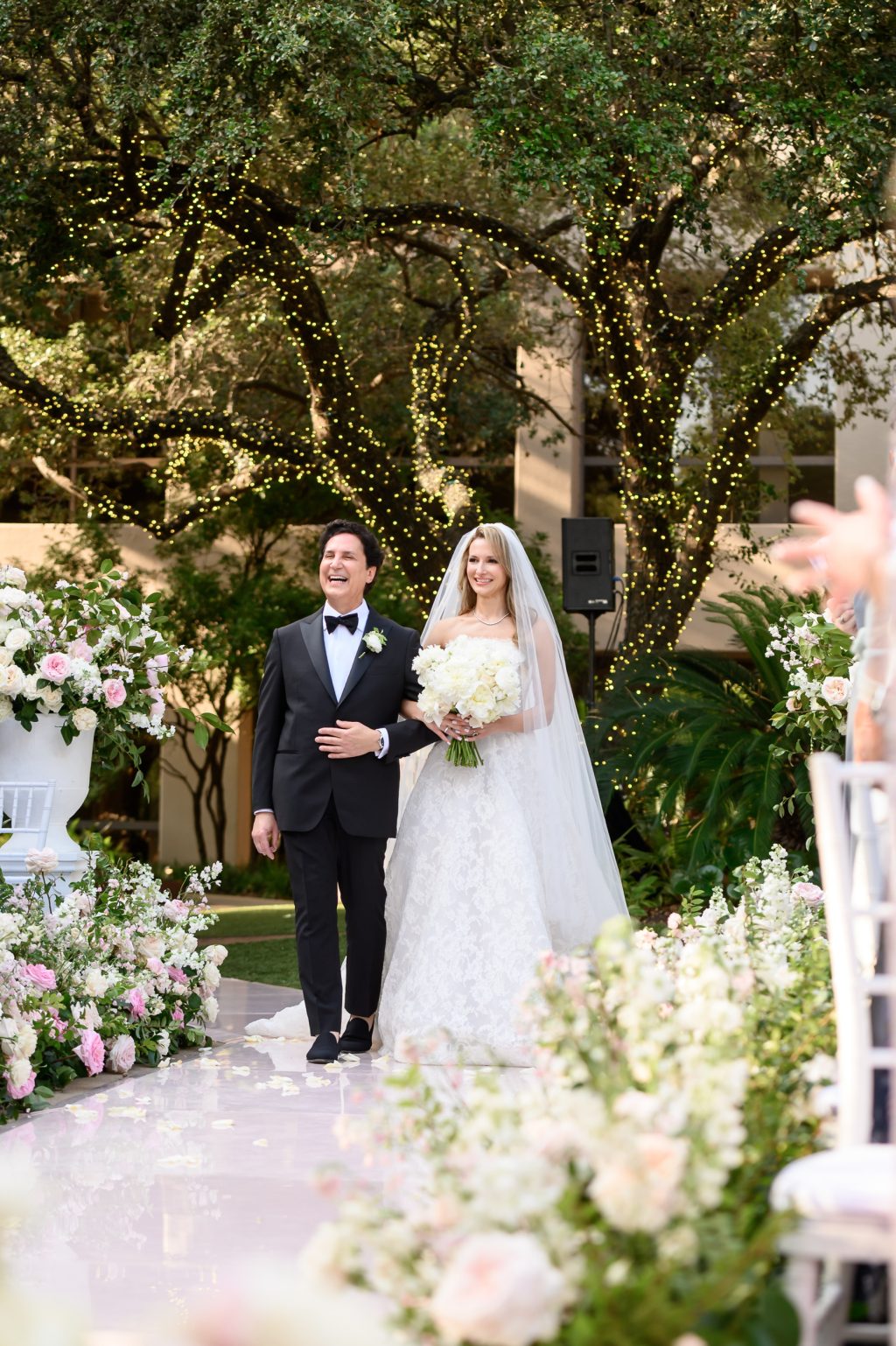 Bride and groom celebrating beneath a lush floral wedding arch