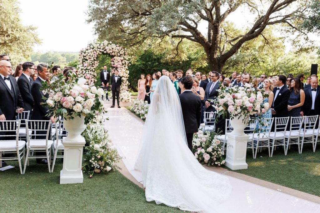 Bride and groom walking down a pink ceremony aisle at Four Seasons Austin
