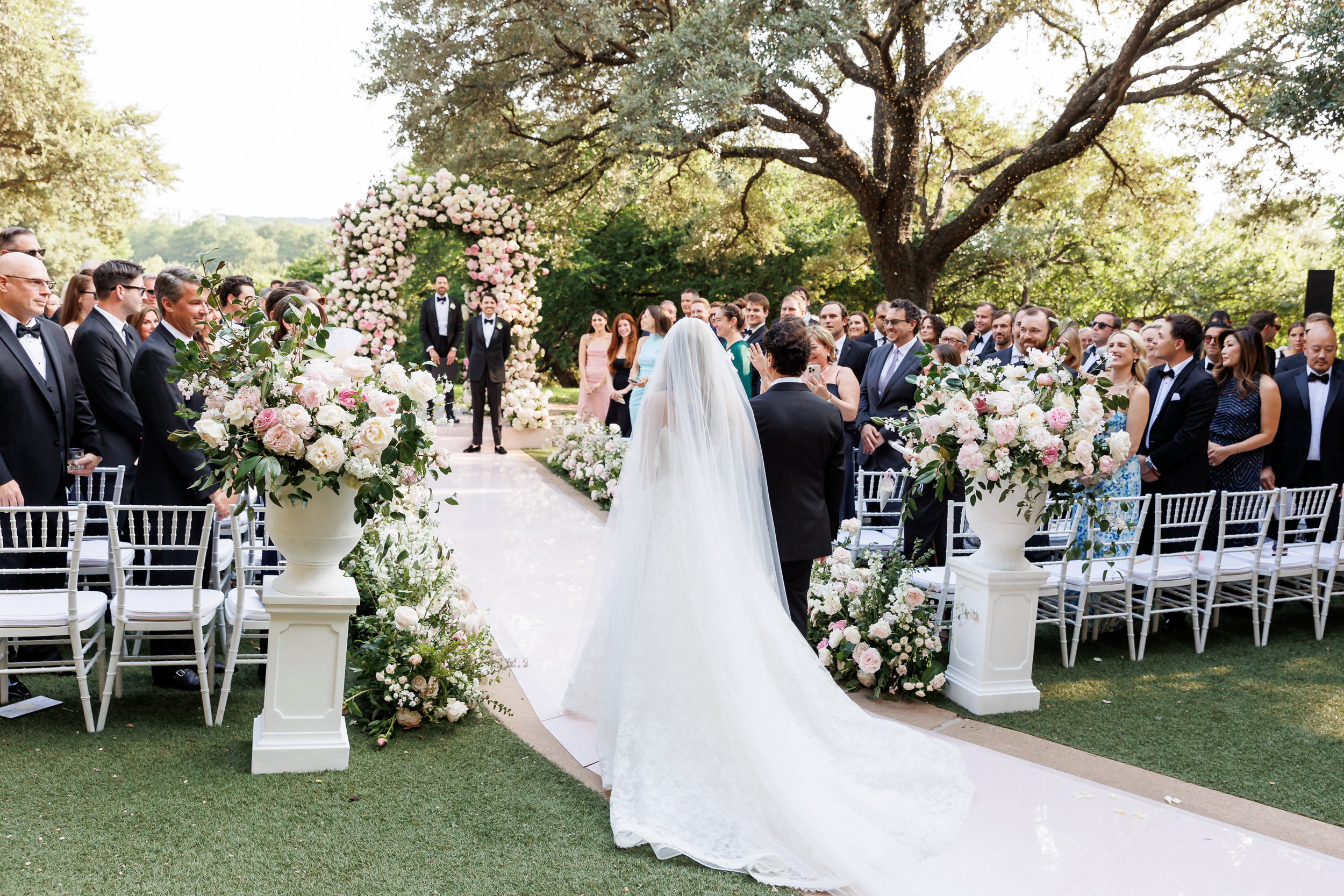 Bride and groom walking down a pink ceremony aisle at Four Seasons Austin
