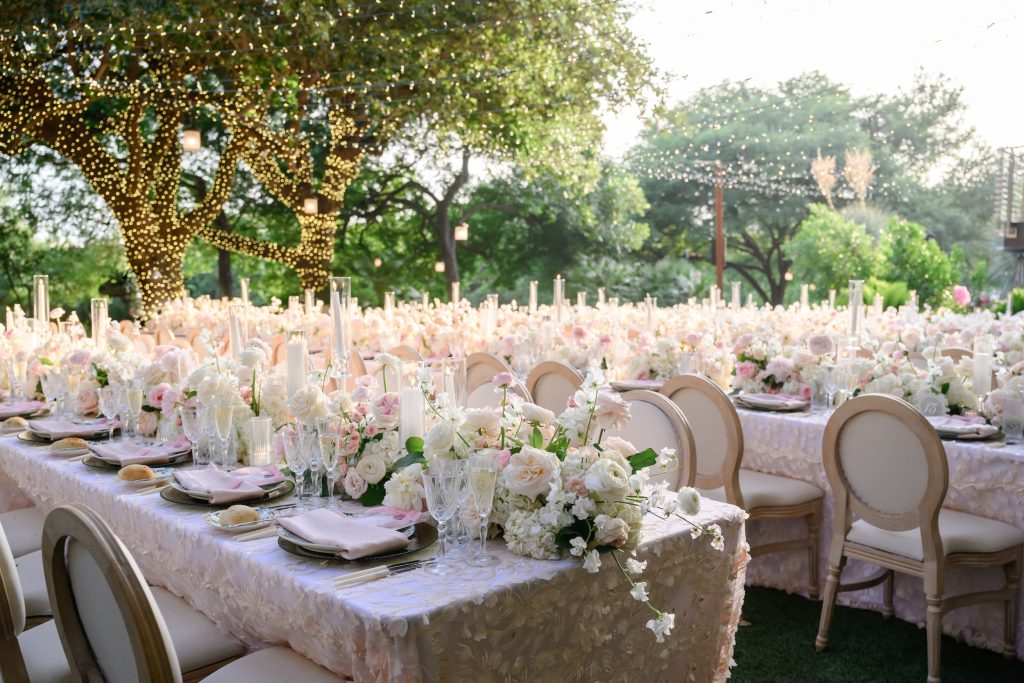 Outdoor wedding dinner tables beneath the trees at Four Seasons Austin lawn