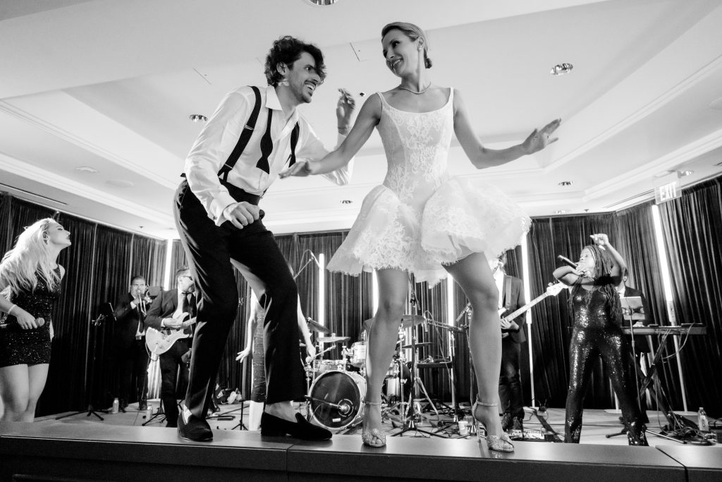 Bride wearing a lace mini reception dress with bubble skirt during her Four Seasons Austin wedding