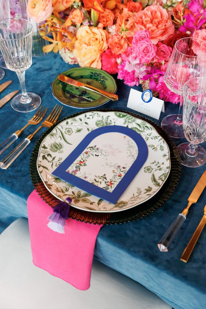 Elegant table setting with floral decor. Custom menu, velvet blue linens.