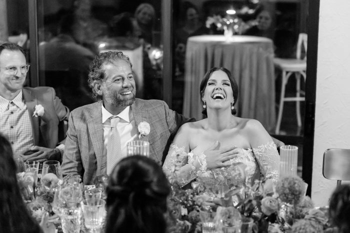 Candid photograph of couple laughing at their intimate dinner for their receptoin