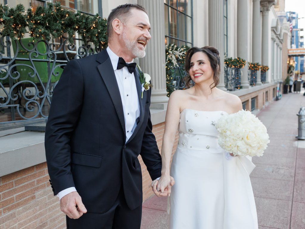 Bride and groom walking together outside The St. Anthony Hotel