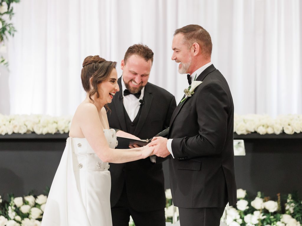 Bride and groom exchanging rings during their New Year’s Eve ceremony in Peraux Room