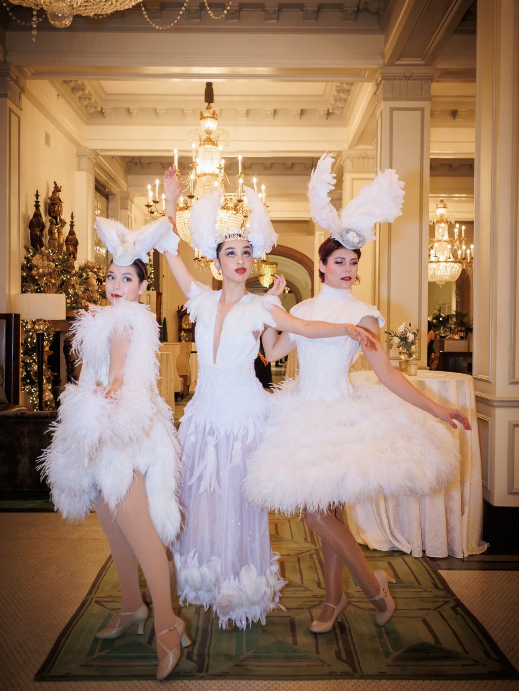 Performers in white feather costumes during a New Year’s Eve wedding at The St. Anthony Hotel