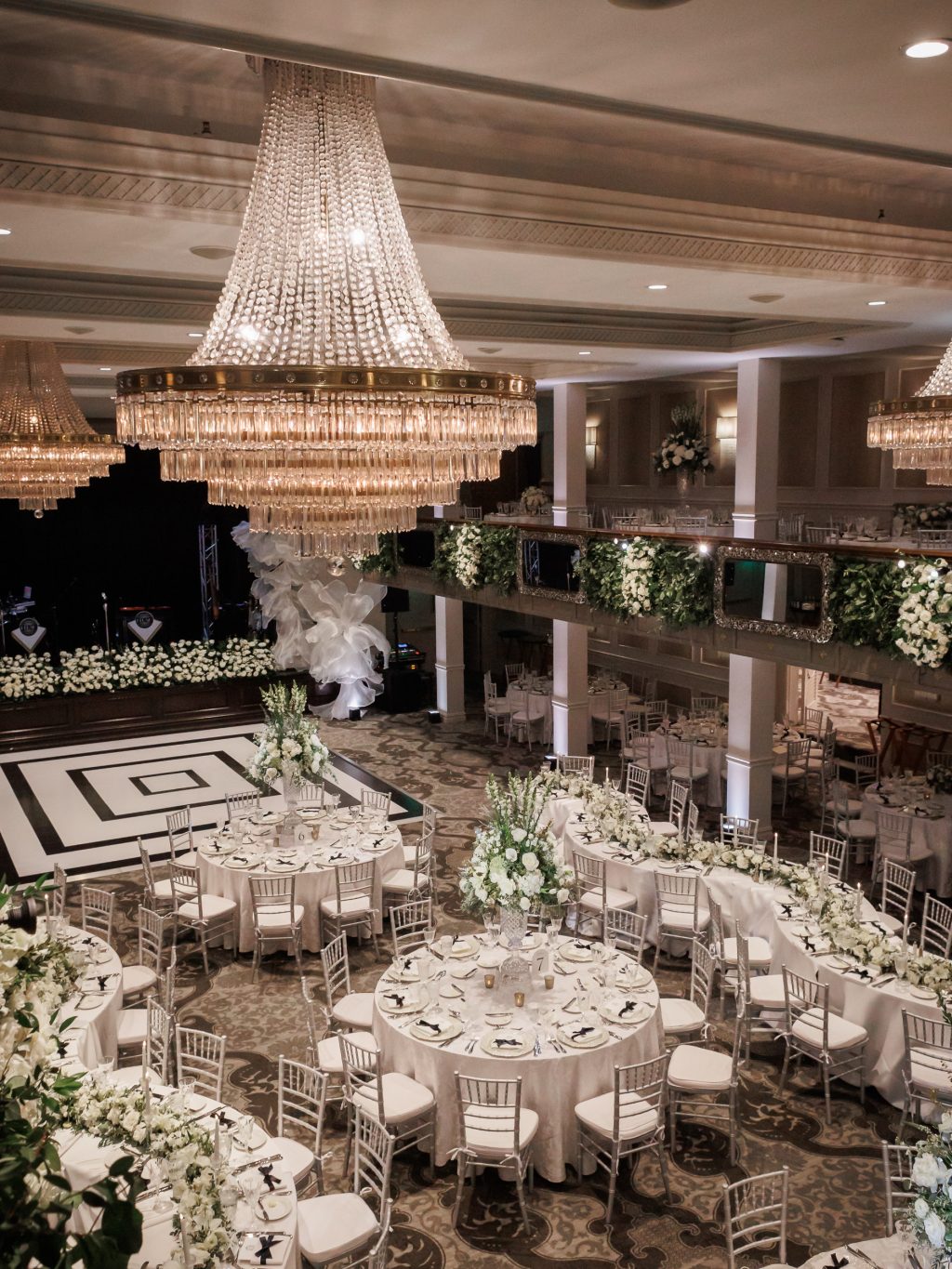 Candlelit reception with white florals and greenery inside Anacacho ballroom at The St. Anthony Hotel
