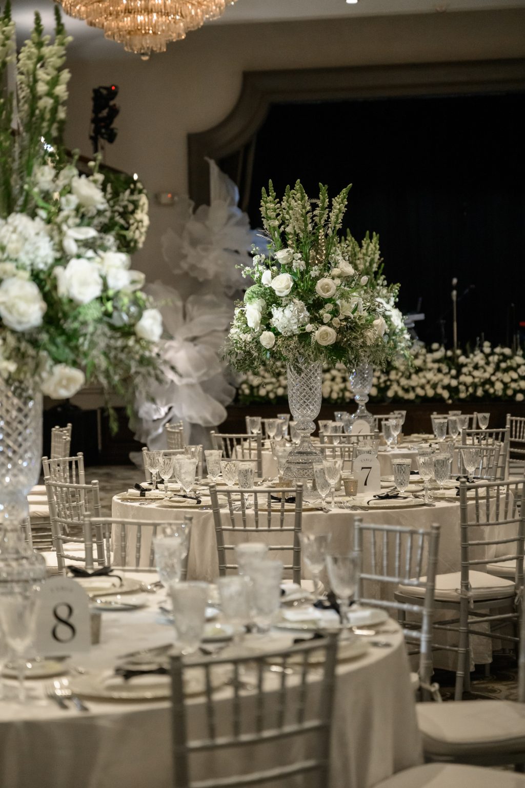 Reception table with white flowers, greenery and crystal glassware at The St. Anthony Hotel