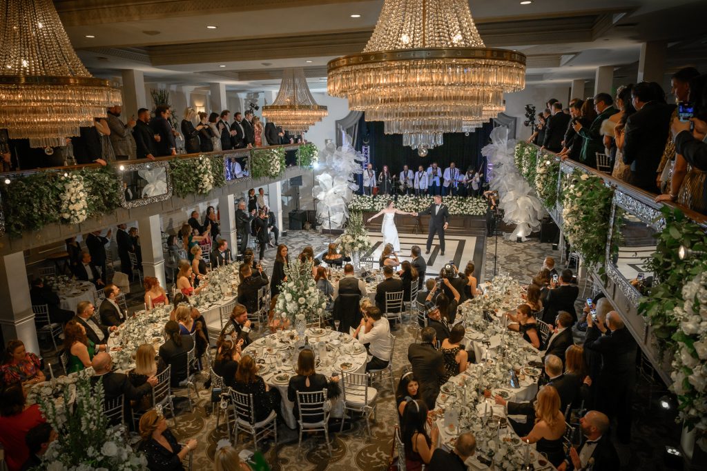 Bride and groom dancing beneath chandeliers during their St. Anthony Hotel wedding reception