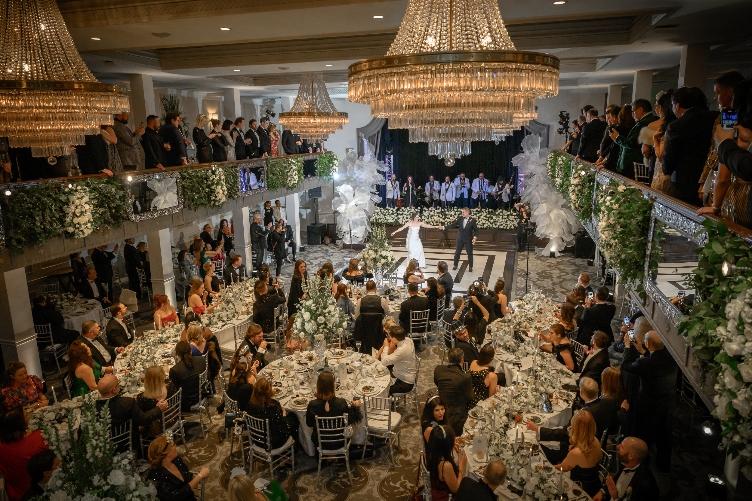 Bride and groom dancing beneath chandeliers during their St. Anthony Hotel wedding reception