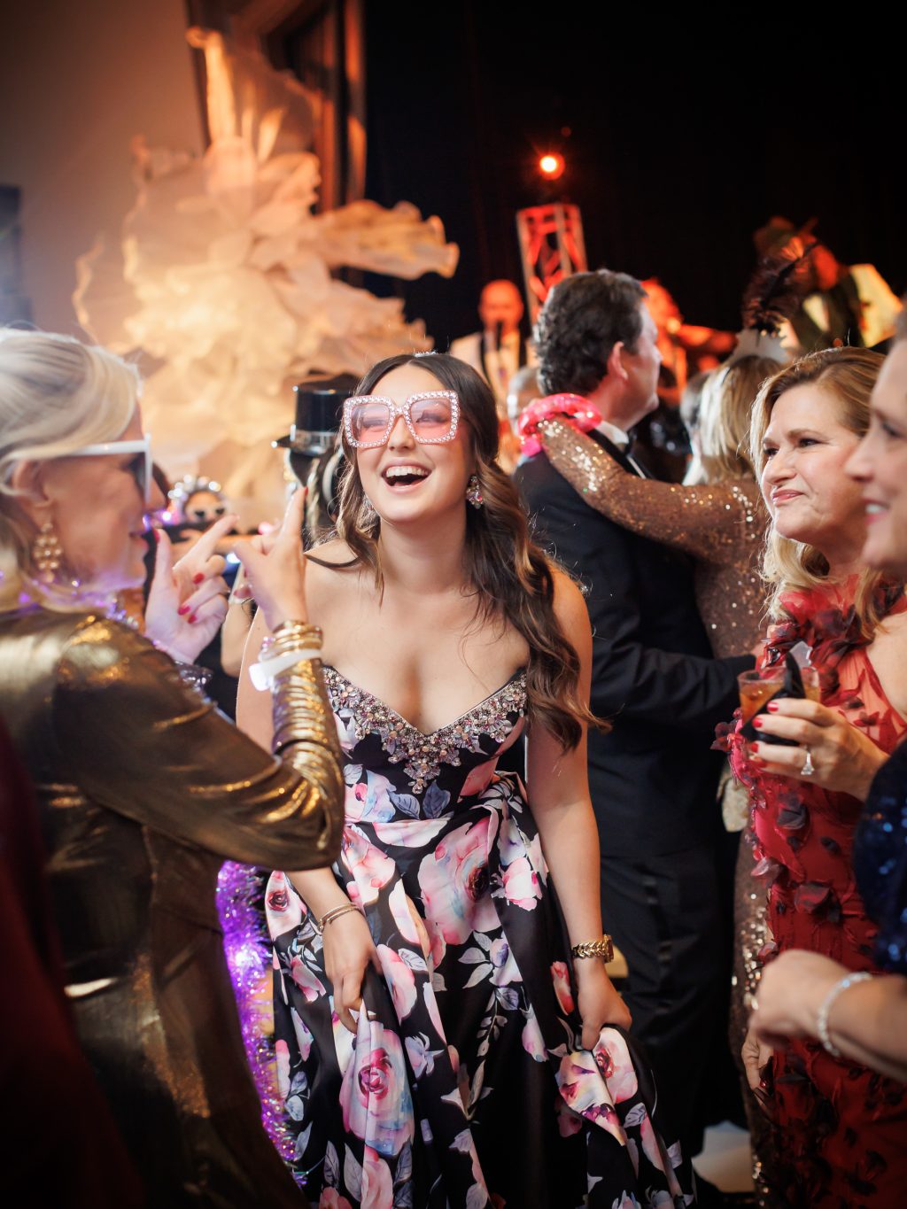 Bride wearing New Year’s Eve glasses while dancing with guests