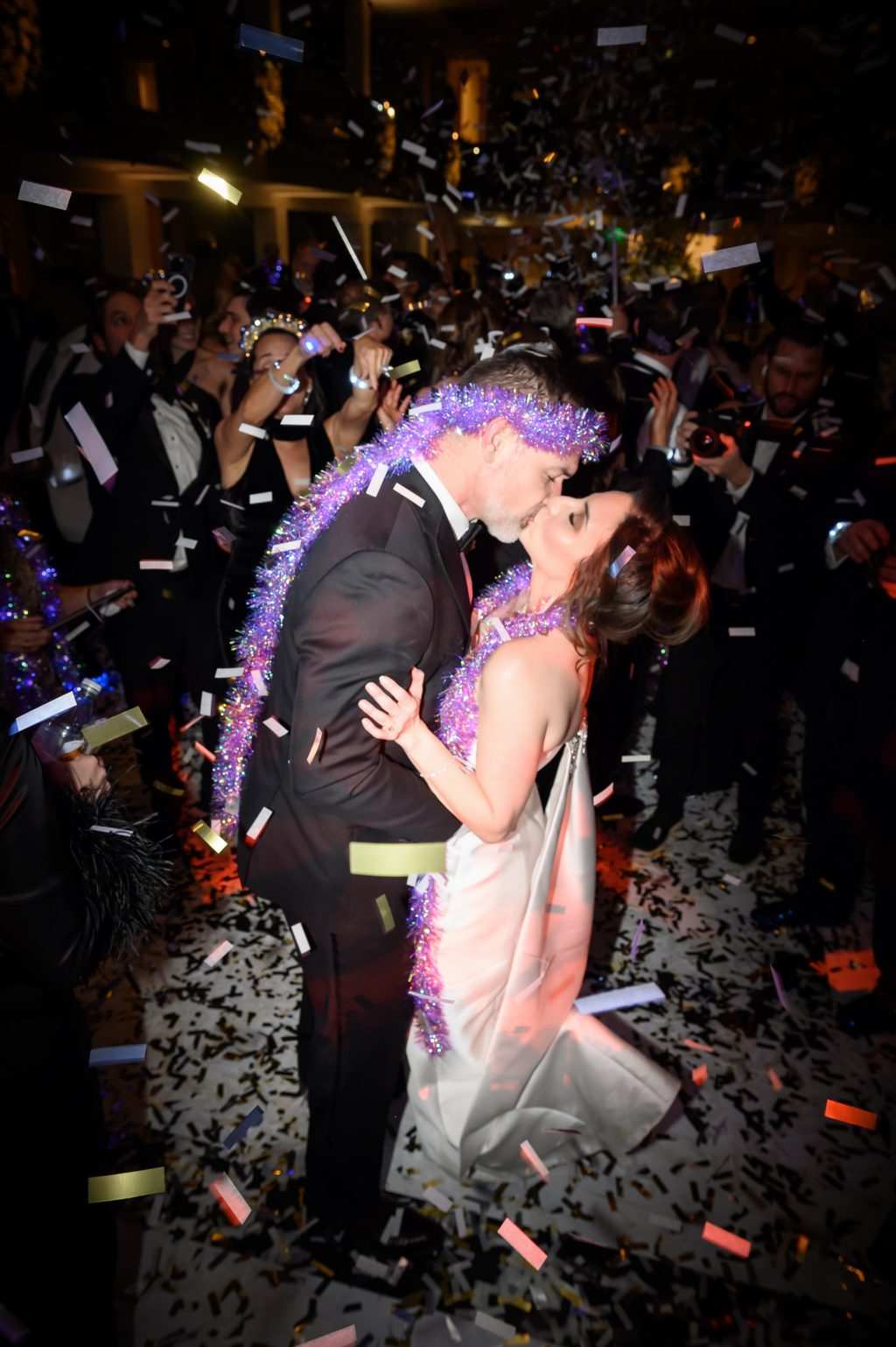 Bride and groom kissing beneath confetti during their New Year’s Eve wedding