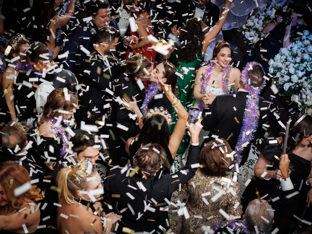 Bride celebrating with wedding guests during the New Year’s Eve confetti drop
