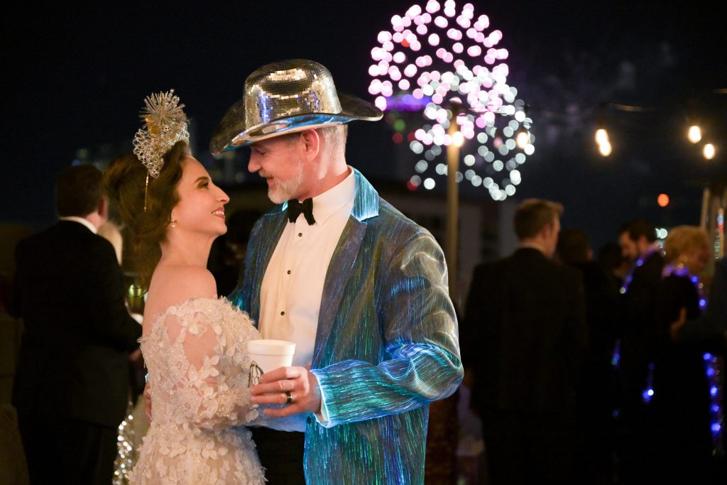Wedding guests wearing festive New Year’s Eve hats during the late night celebration
