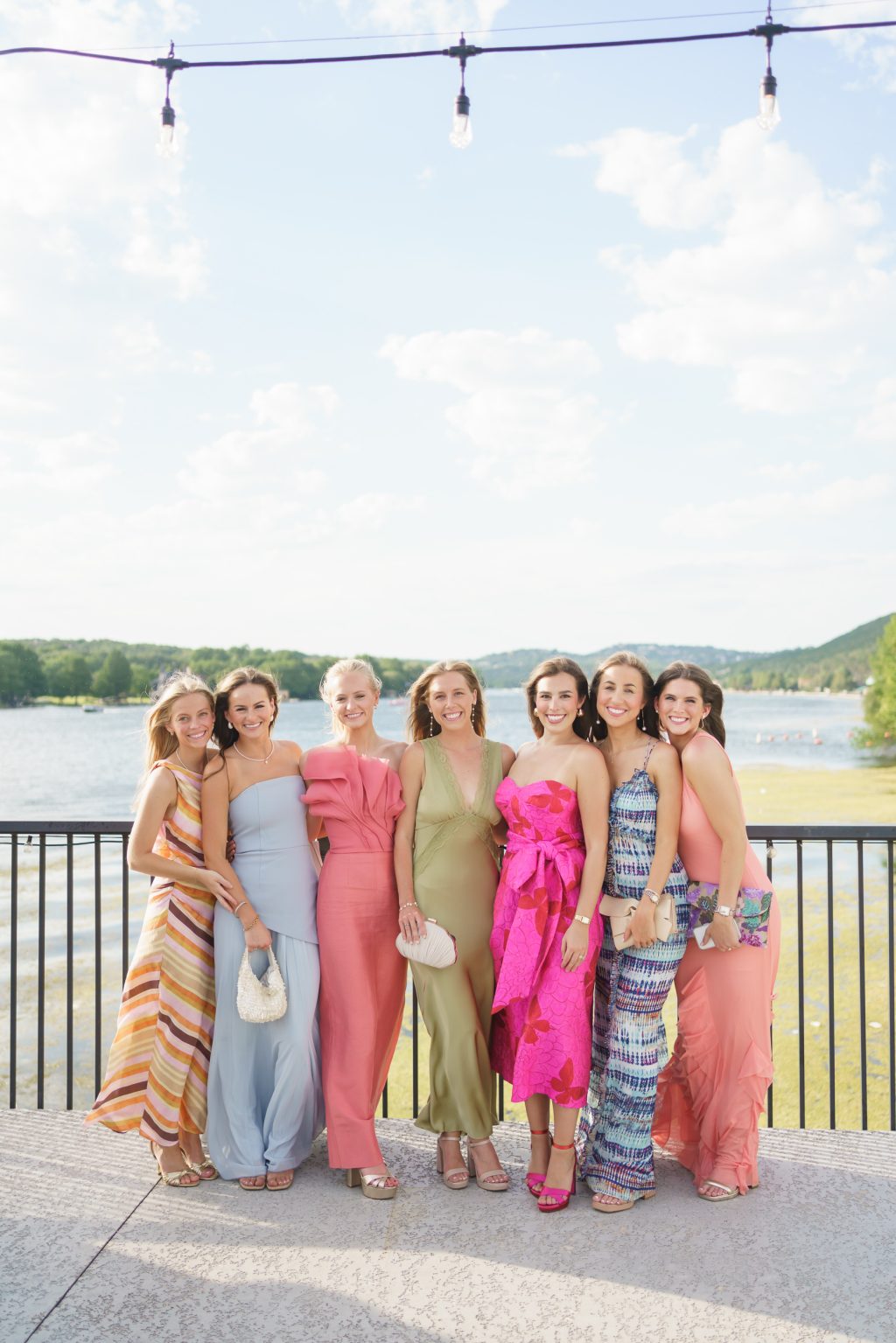 Women in colorful cocktail dresses overlooking lake Austin during the cocktail hour on the dock at westwood country club