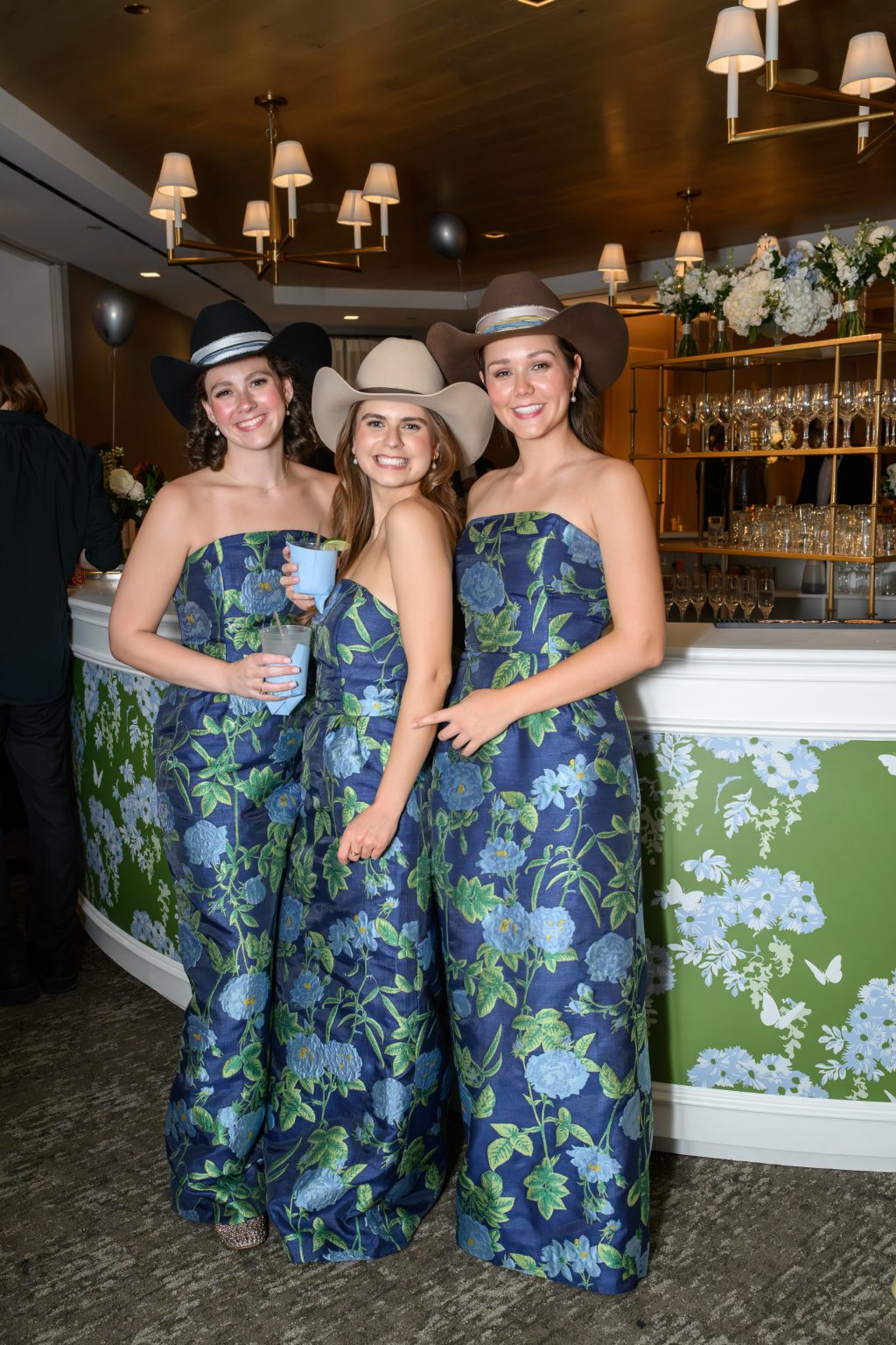 Bridesmaids wearing blue and white dresses at the reception by the custom bar facade