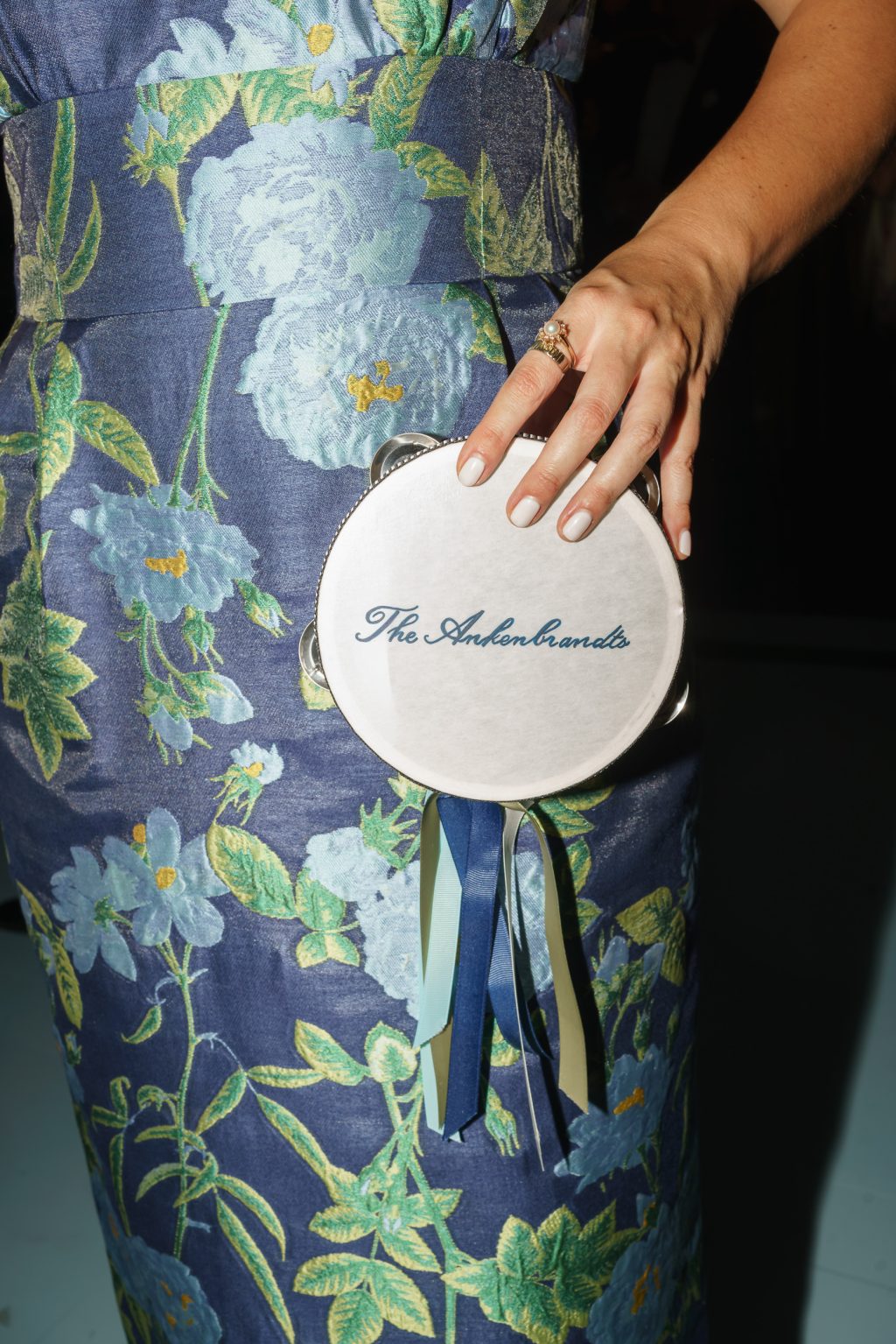Custom tambourine with blue ribbons and the couples name at the reception