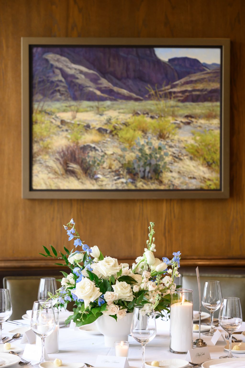 Blue and white floral centerpiece beneath Texas artwork at the Headliners Club