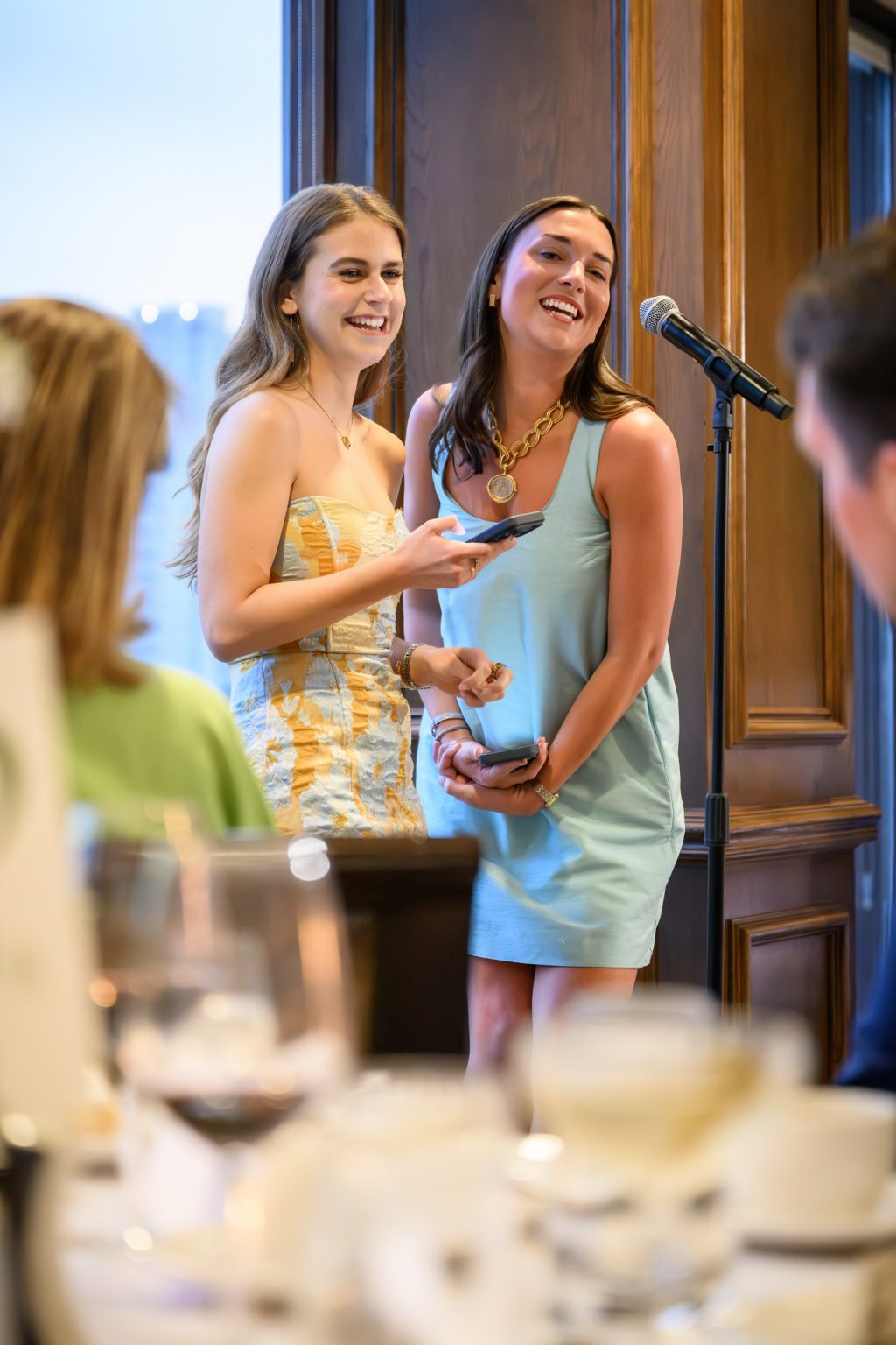 Friends give a joyful toast during Maddy and Will’s Headliners Club rehearsal dinner