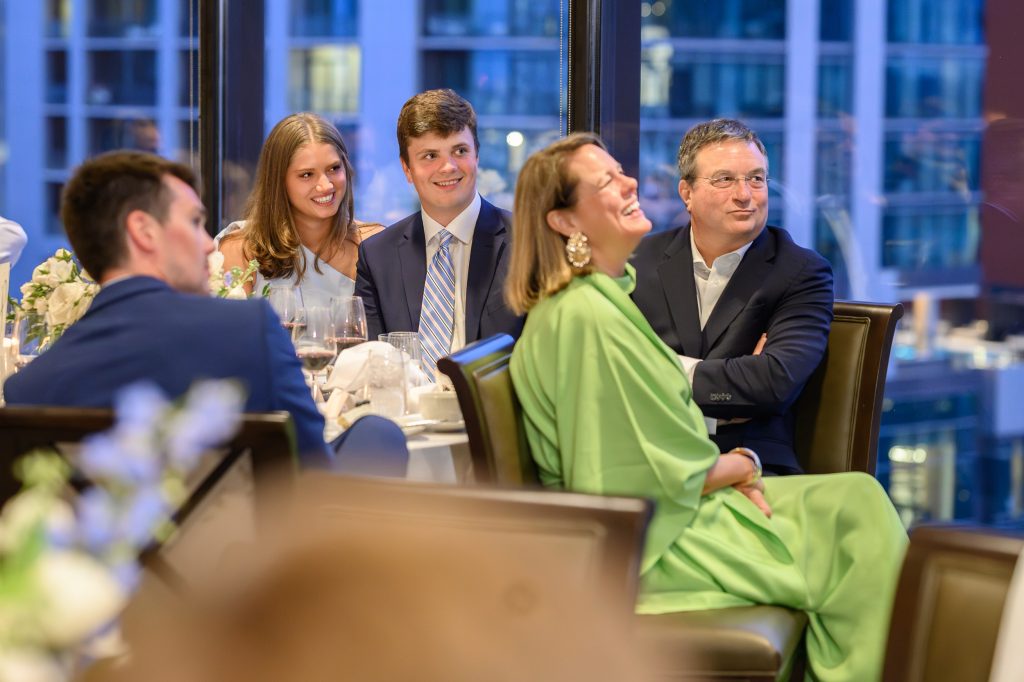 Family and friends react during speeches at the Headliners Club rehearsal dinner