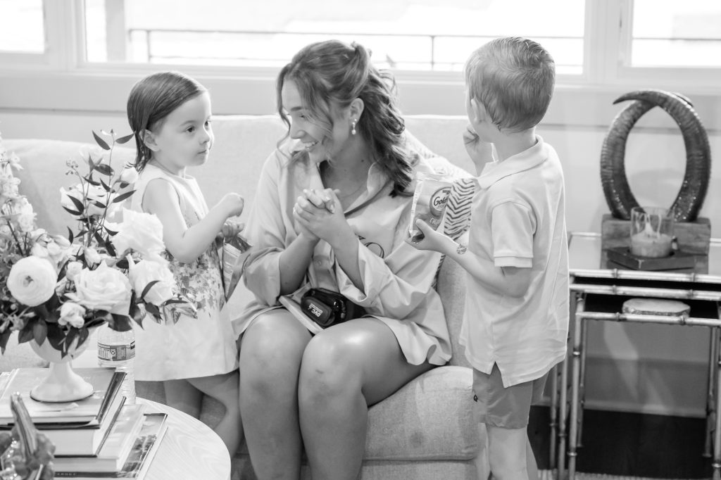 Bride shares a candid moment with young family members while getting ready at her childhood home
