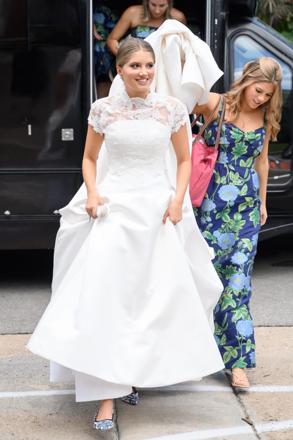 Maddy steps out in her wedding gown with help from a bridesmaid