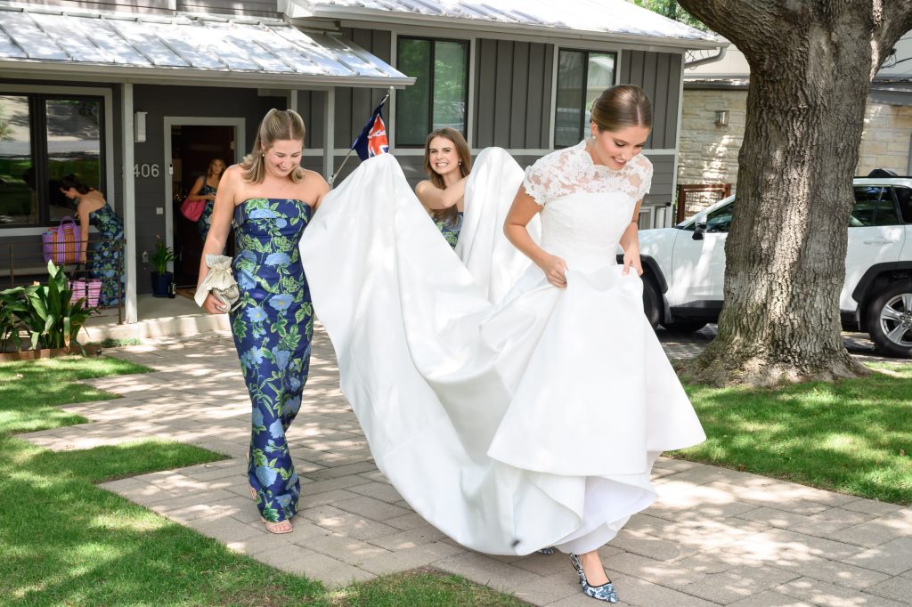 Bride and bridesmaid laugh while leaving her childhood home for the Tarrytown church ceremony