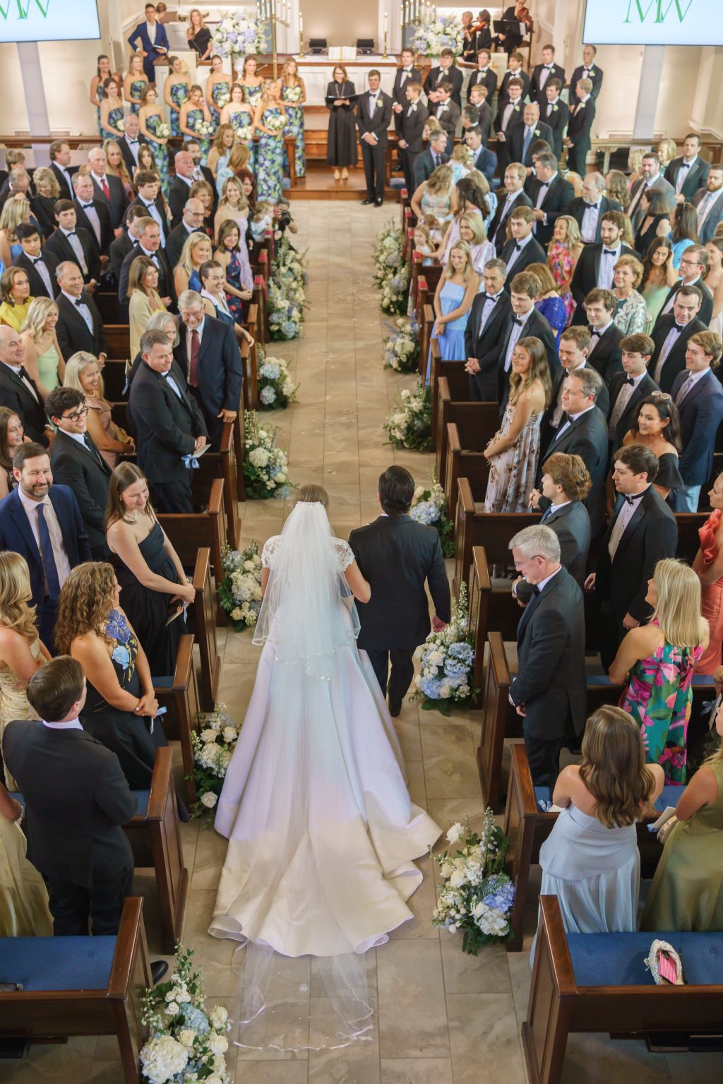Overhead view of the bride walking through a full church during her traditional Austin wedding