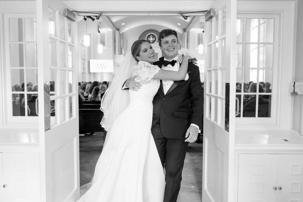 Black and white photograph of Maddy celebrating with Will immediately after their ceremony