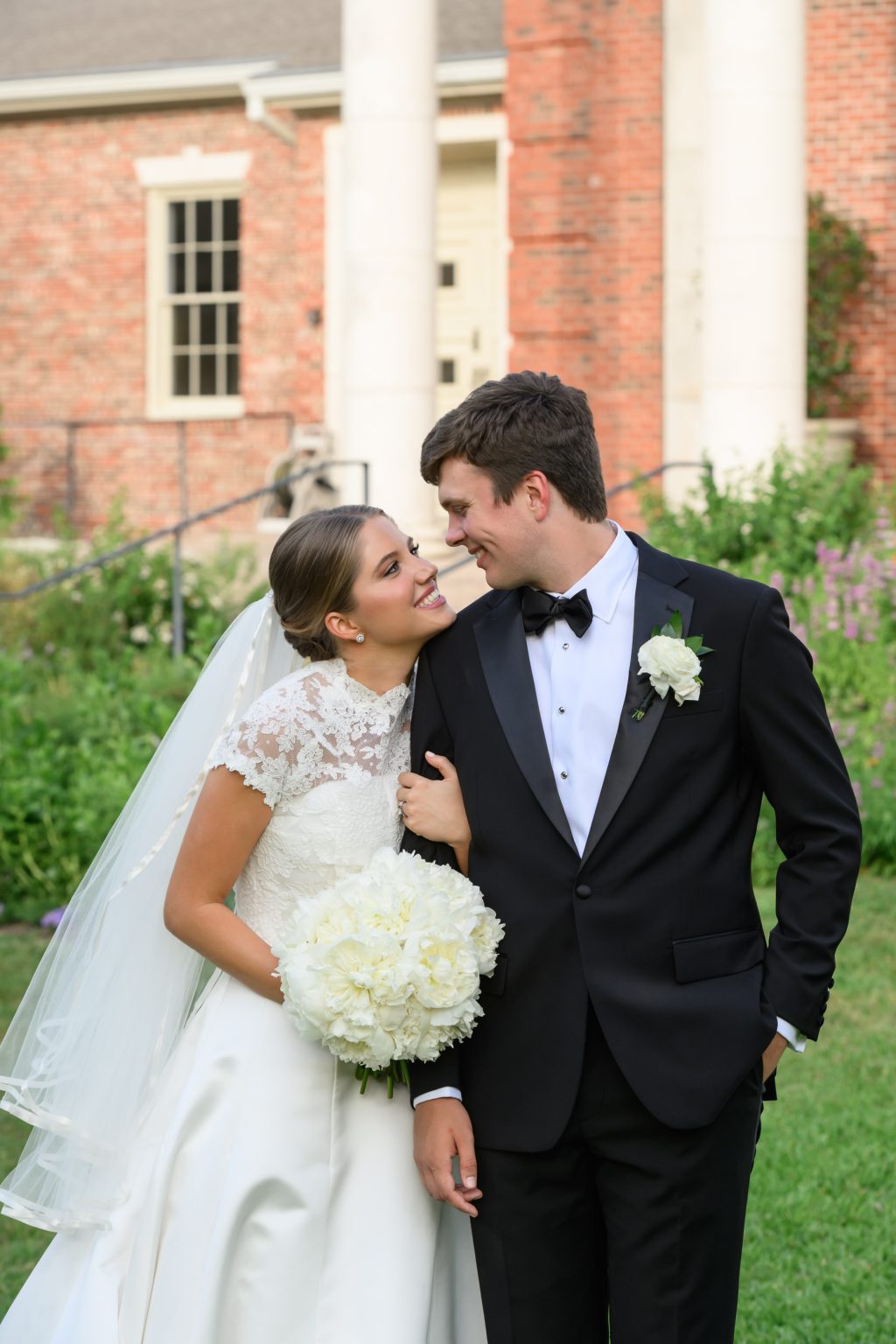 Bride leans toward the groom during portraits outside their Tarrytown church ceremony