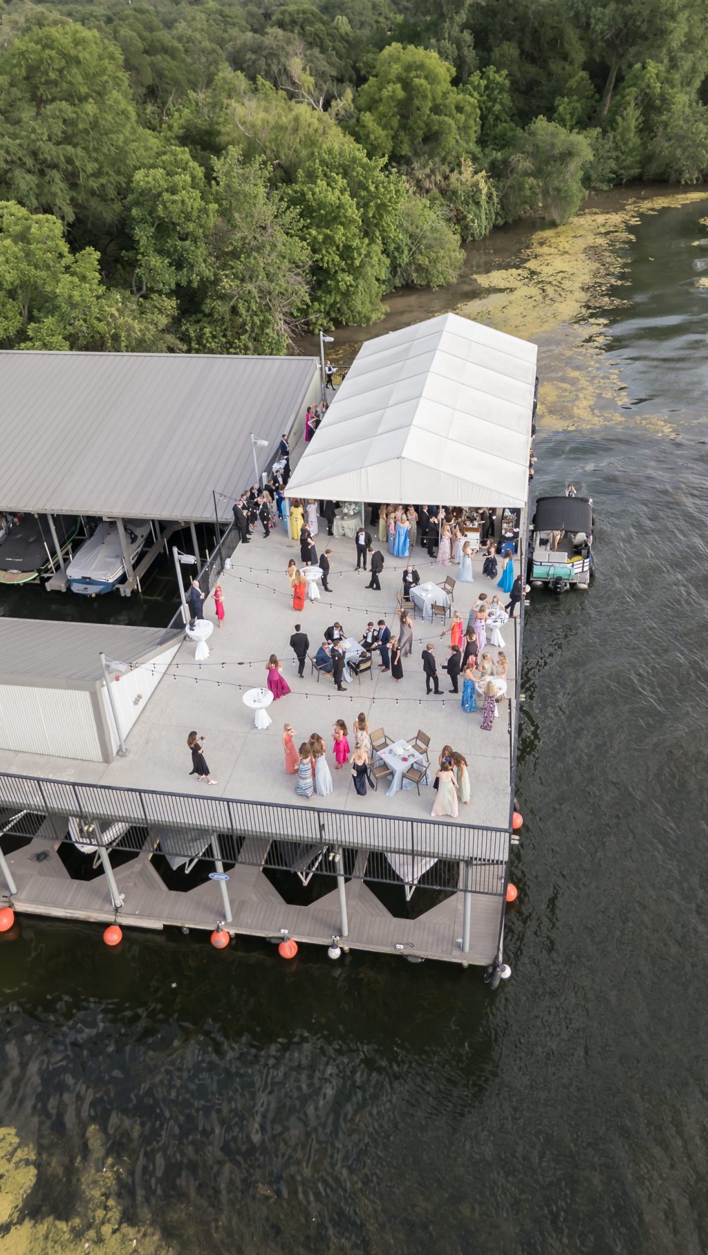 Aerial view of the lakeside dock wedding cocktail hour at Westwood Country Club in Austin photographed with a drone