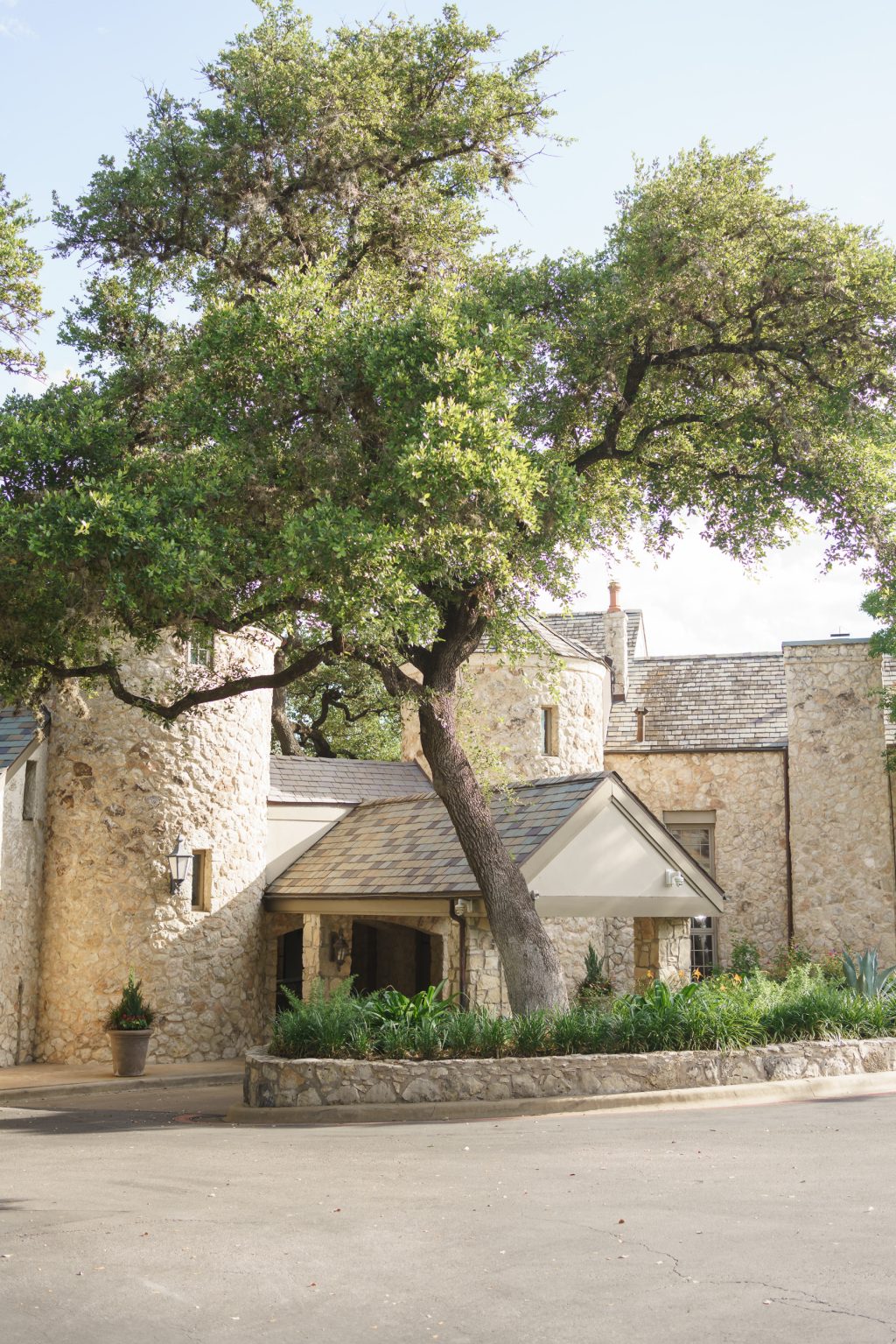 Classic stone entrance surrounded by mature oak trees at Westwood Country Club