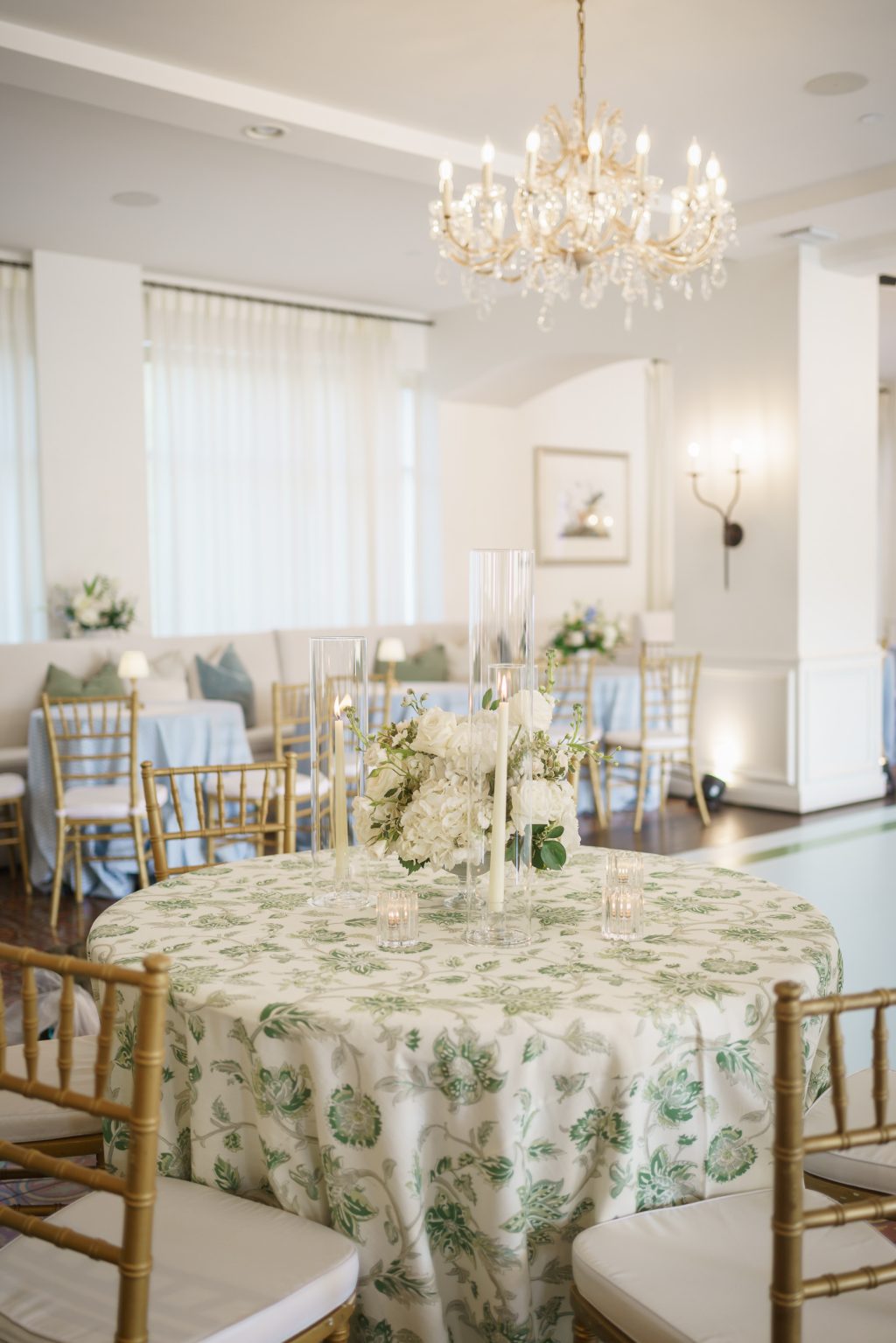 Green patterned linens, gold chairs, and white flowers inside Westwood Country Club