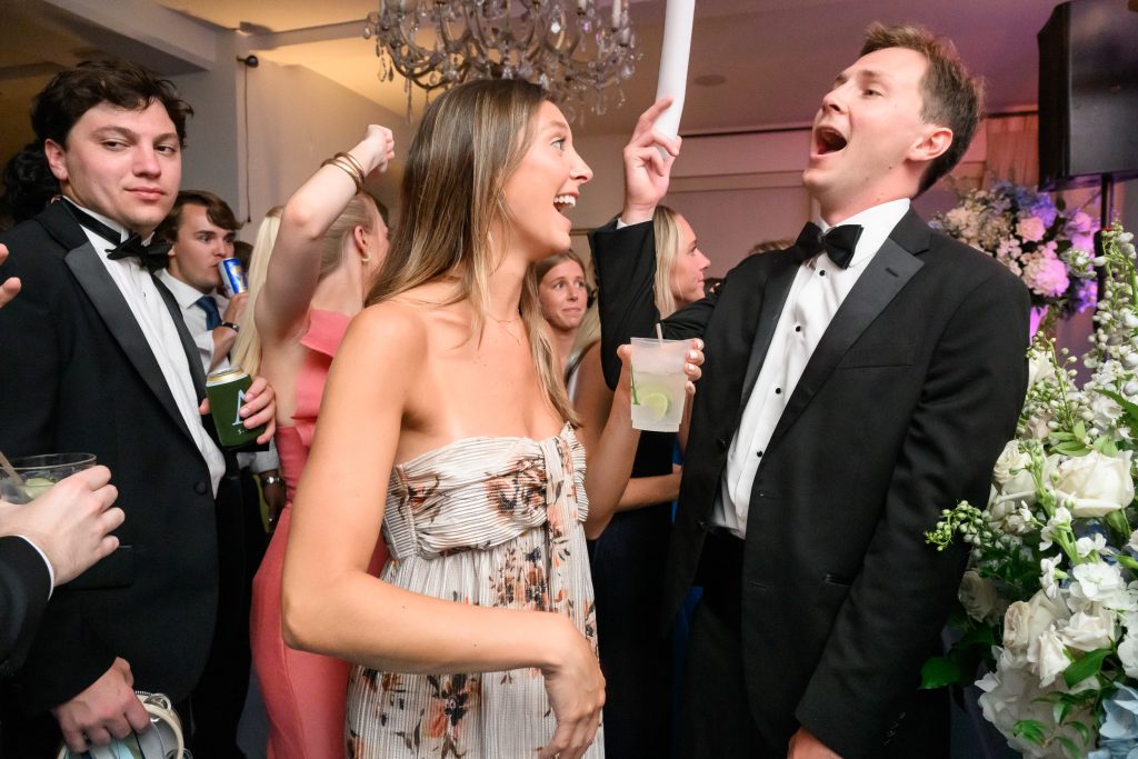 Groom and guests sing and dance together during the Austin wedding reception