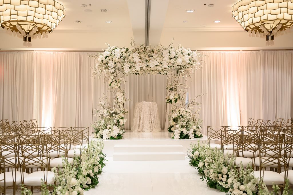 White floral chuppah and ceremony aisle inside the Four Seasons Austin Ballroom