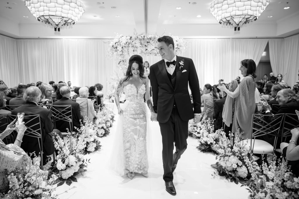 Newlyweds walking down the aisle after an indoor wedding ceremony at Four Seasons Austin