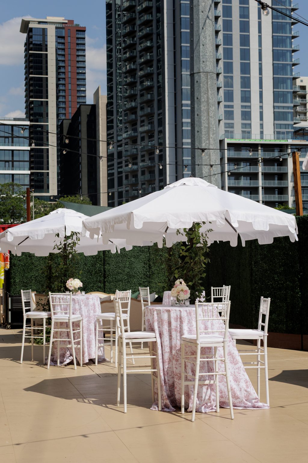 Cocktail tables and umbrellas set up on the terrace for cocktail hour at the Four Seasons