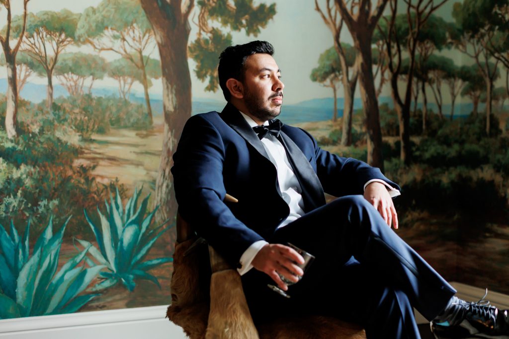 Groom seated for a portrait in the Magnolia Suite at Commodore Perry Estate