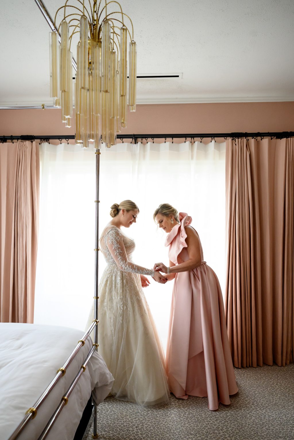 Bride getting ready with family in the pink bedroom of the Mr. and Mrs. Perry Suite